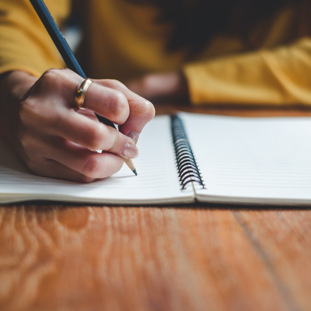Woman writing down notes on her Email Audit & Strategy Session