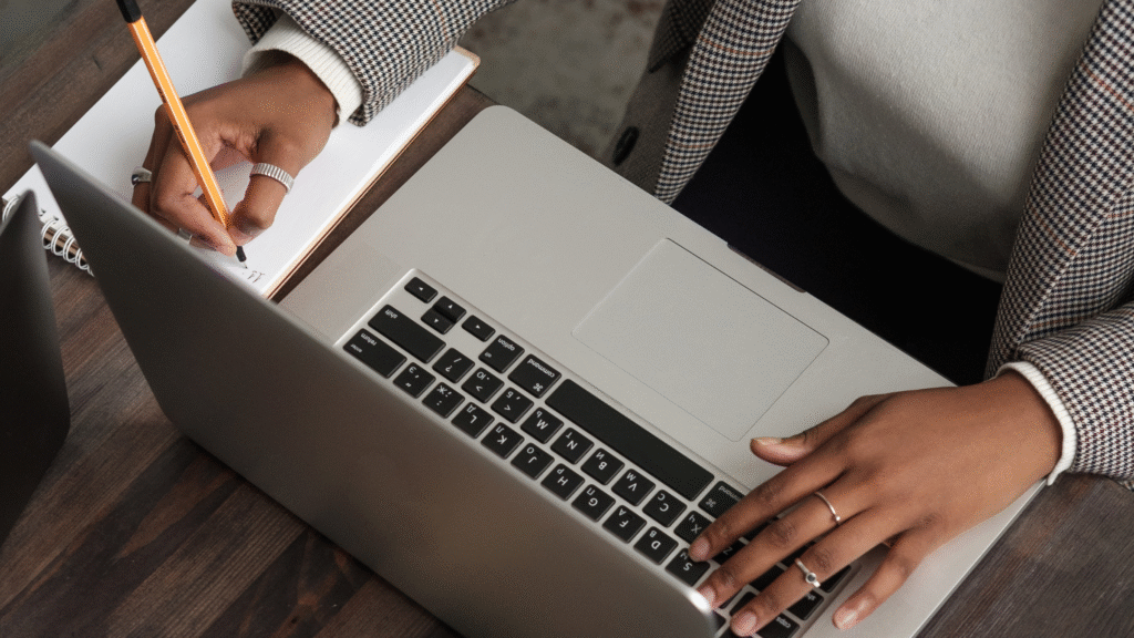 brown woman typing on laptop